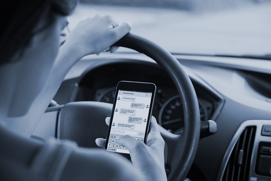Close-up Of Woman Sitting Inside Car Typing Text Message On Mobile Phone