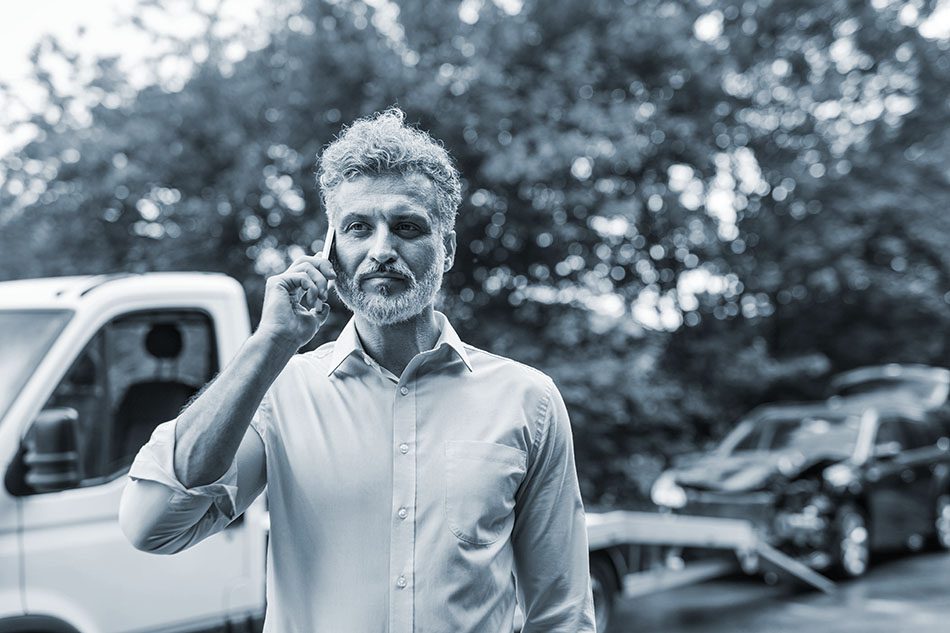 Mature man making a phone call after a car accident. 