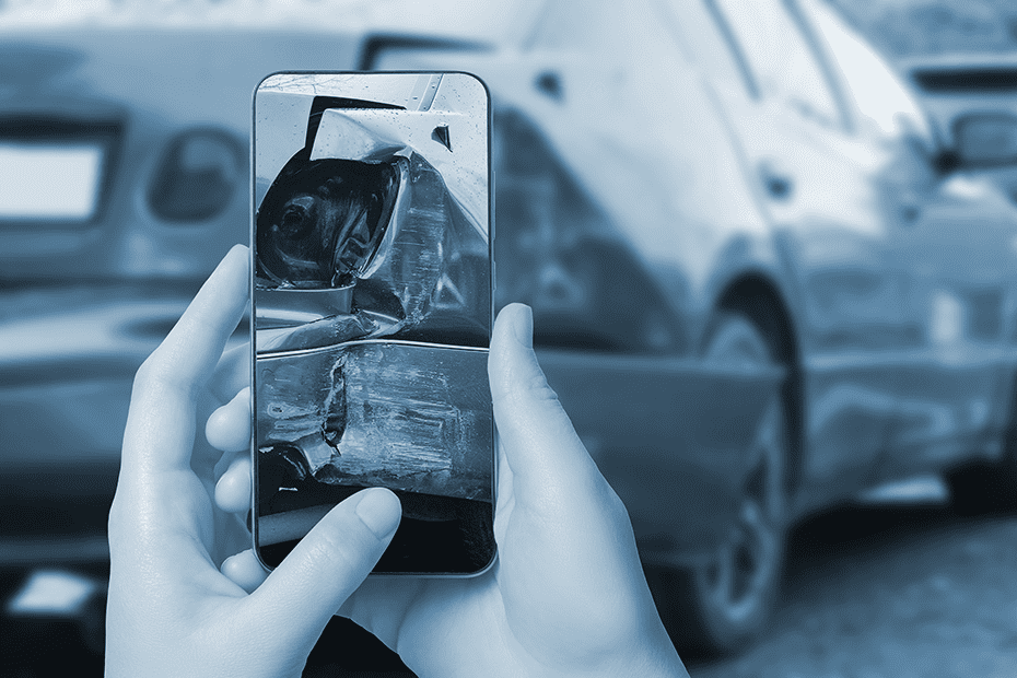 Person takes photos of damaged car with smart phone