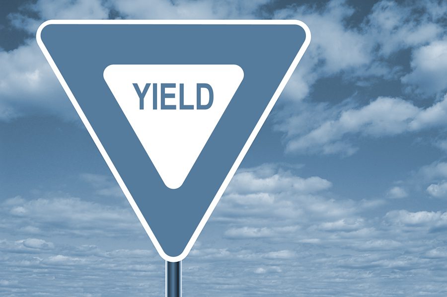 Yield sign with clouds in the background