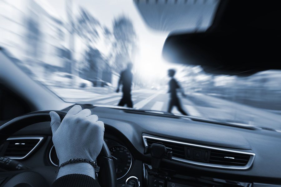 people on a pedestrian crossing and a car braking quickly