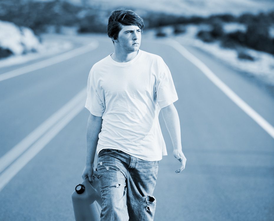 Young Man walk in the road with a gas can 