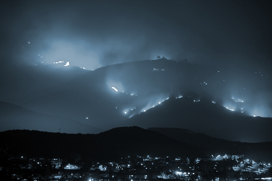 Southern Californian mountains covered in Flames over a neighborhood.